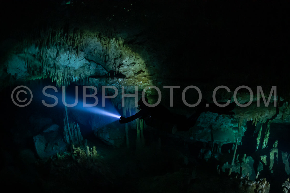 cave diver instructor leading a group of divers in a mexican cenote underwater