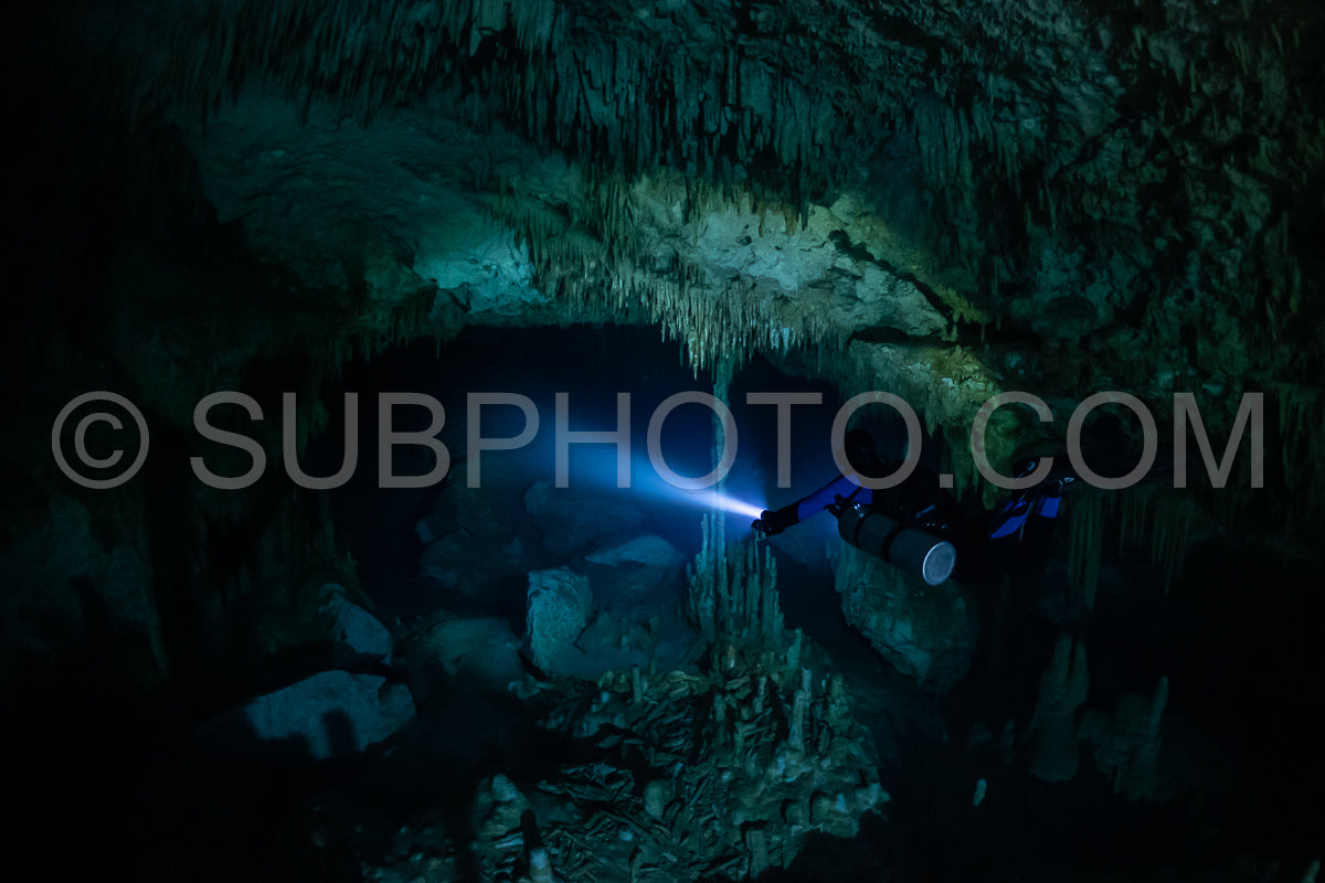 cave diver instructor leading a group of divers in a mexican cenote underwater