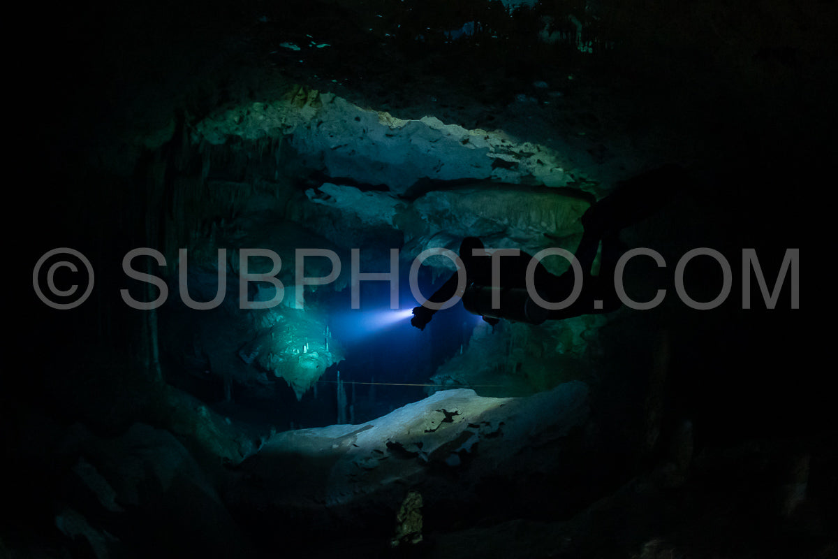 cave diver instructor leading a group of divers in a mexican cenote underwater