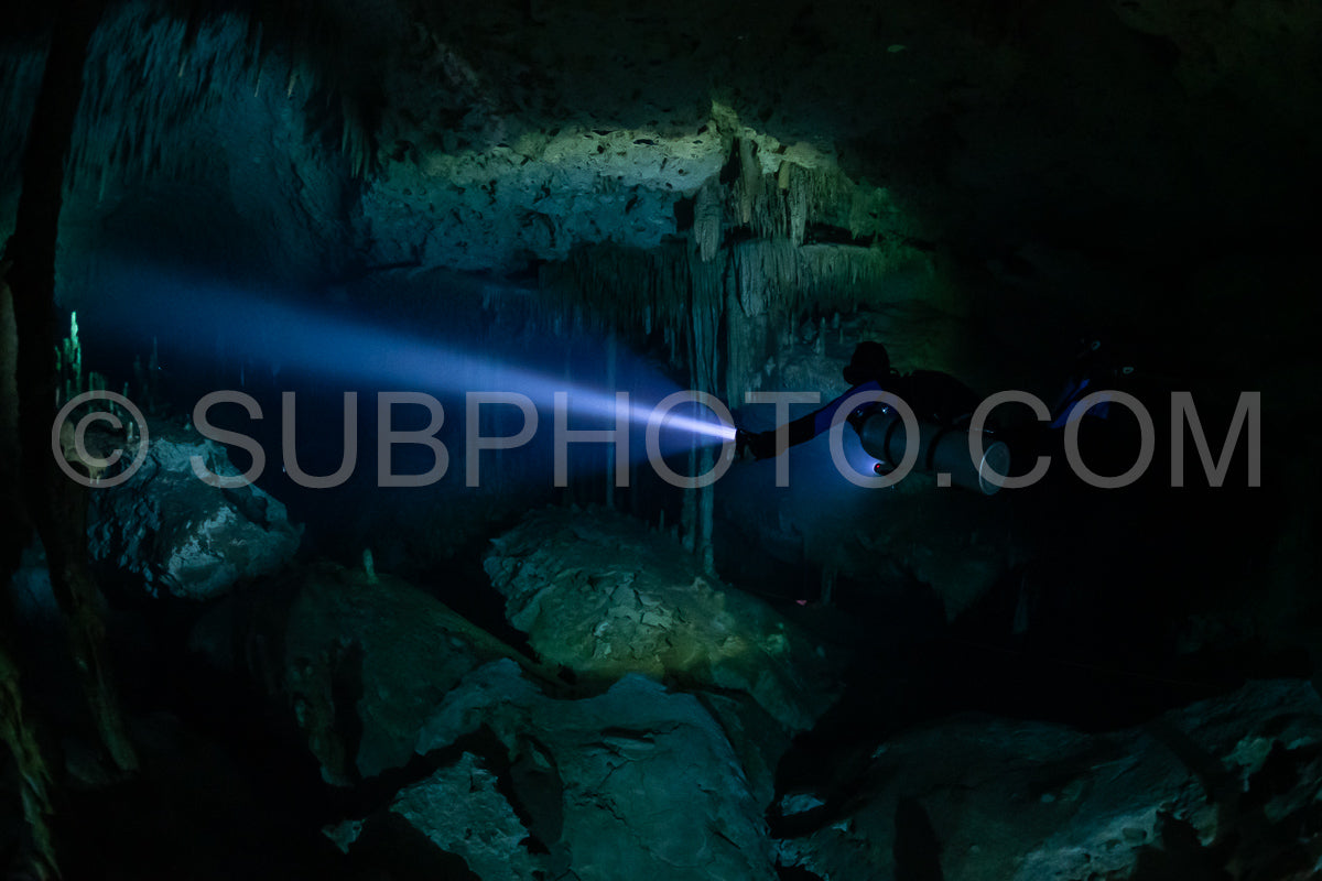 cave diver instructor leading a group of divers in a mexican cenote underwater