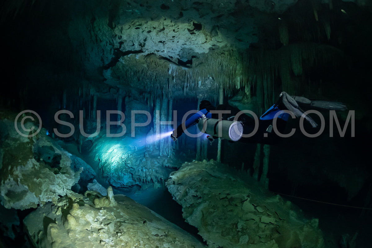 cave diver instructor leading a group of divers in a mexican cenote underwater