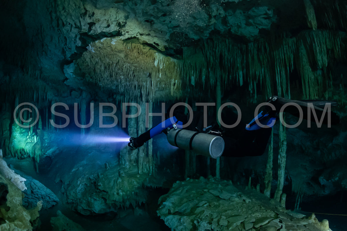 cave diver instructor leading a group of divers in a mexican cenote underwater