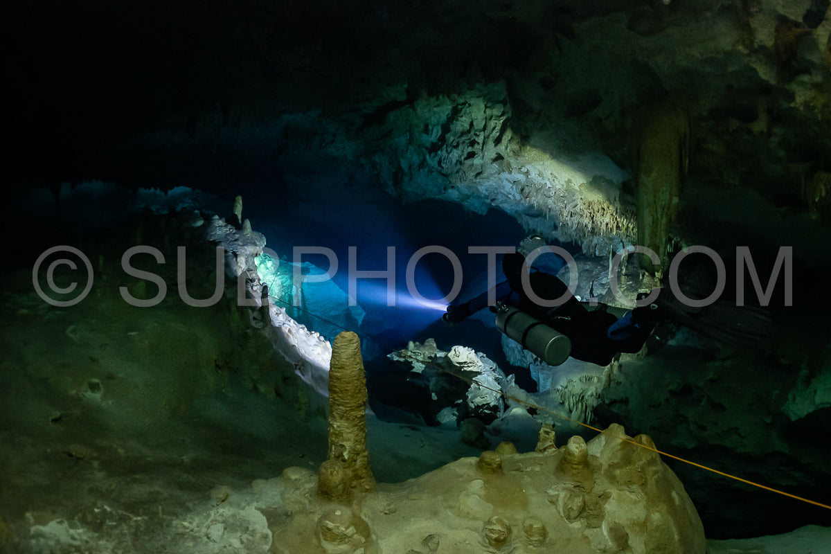 cave diver instructor leading a group of divers in a mexican cenote underwater