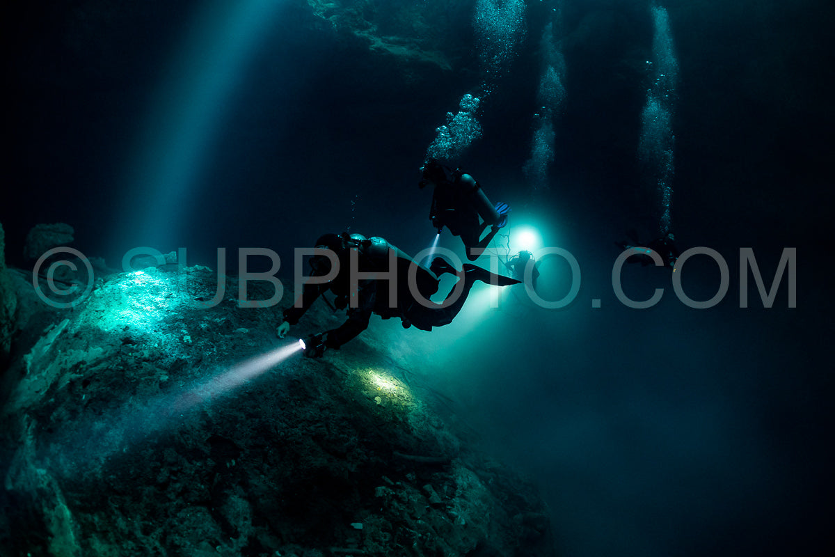 cave diver instructor leading a group of divers in a mexican cenote underwater