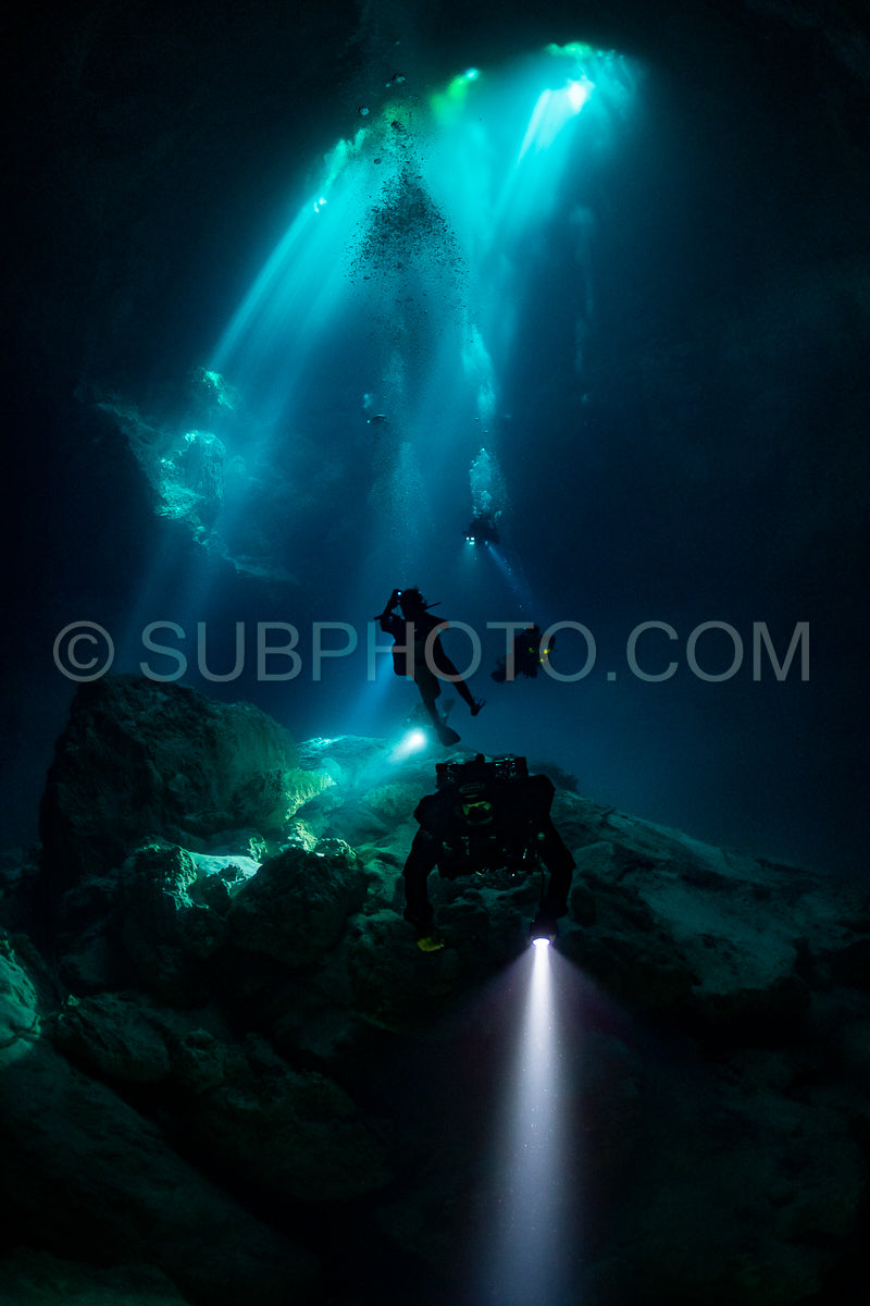 cave diver instructor leading a group of divers in a mexican cenote underwater