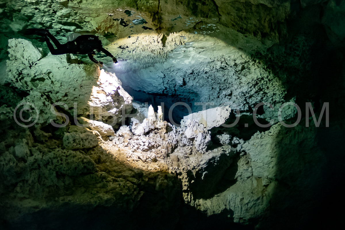 cave diver instructor leading a group of divers in a mexican cenote underwater
