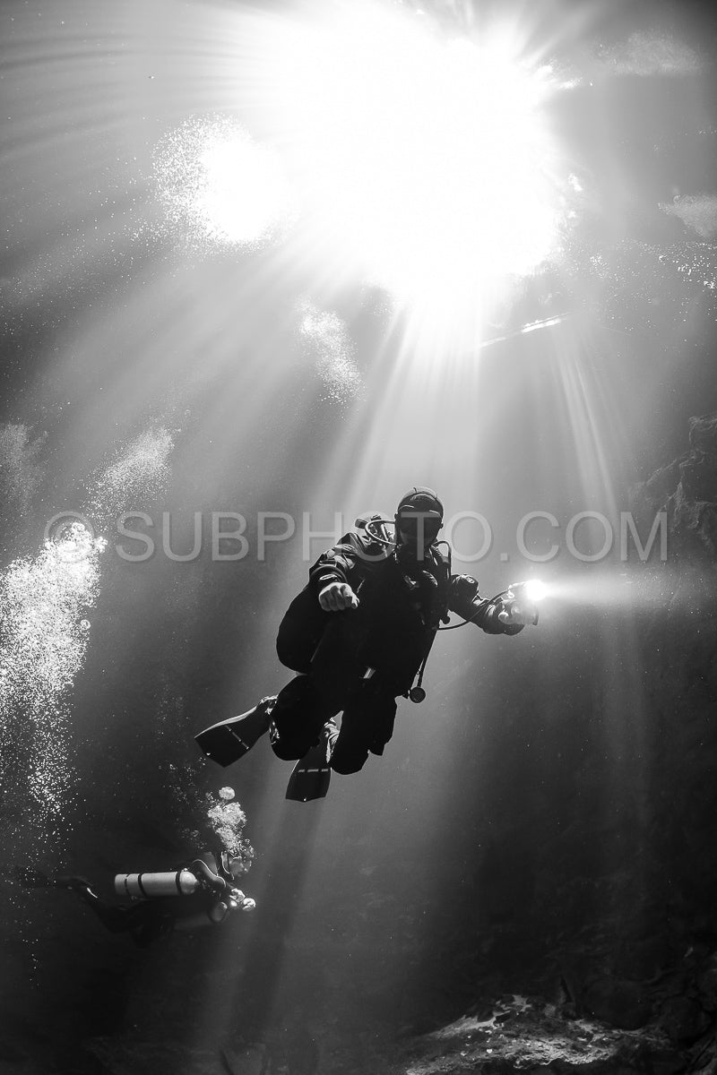 cave diver instructor leading a group of divers in a mexican cenote underwater