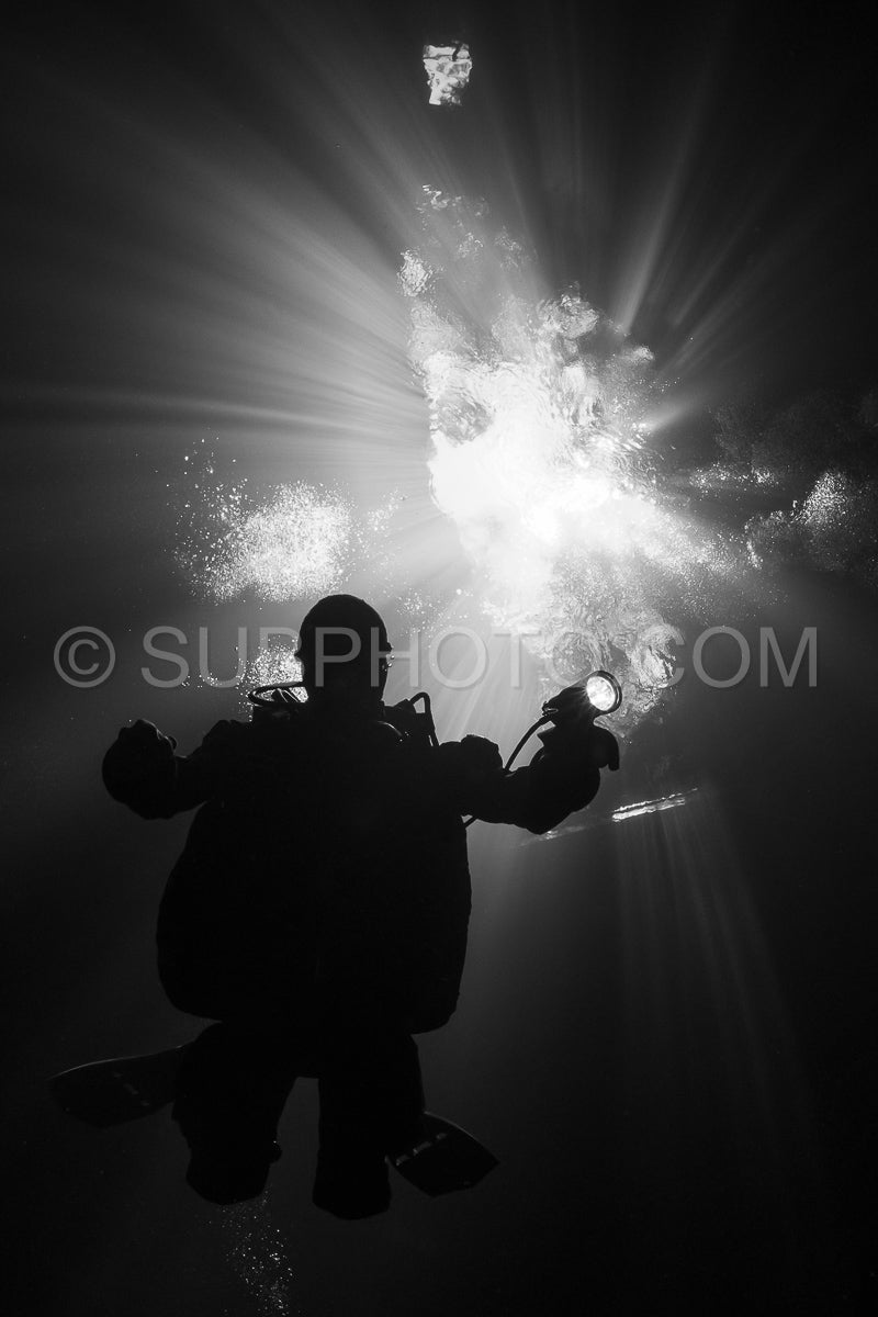 cave diver instructor leading a group of divers in a mexican cenote underwater