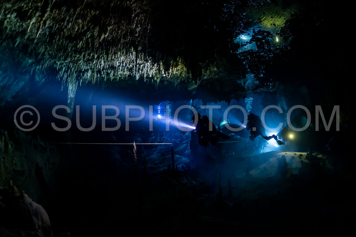 cave diver instructor leading a group of divers in a mexican cenote underwater