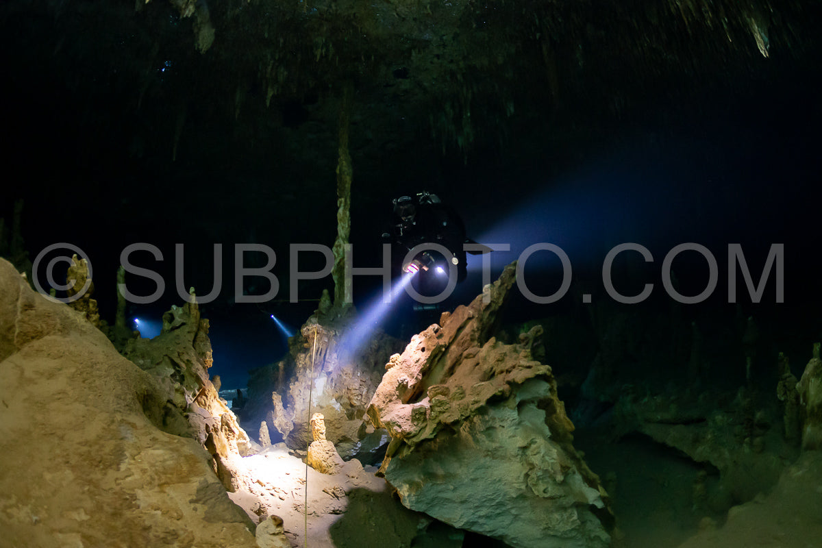cave diver instructor leading a group of divers in a mexican cenote underwater