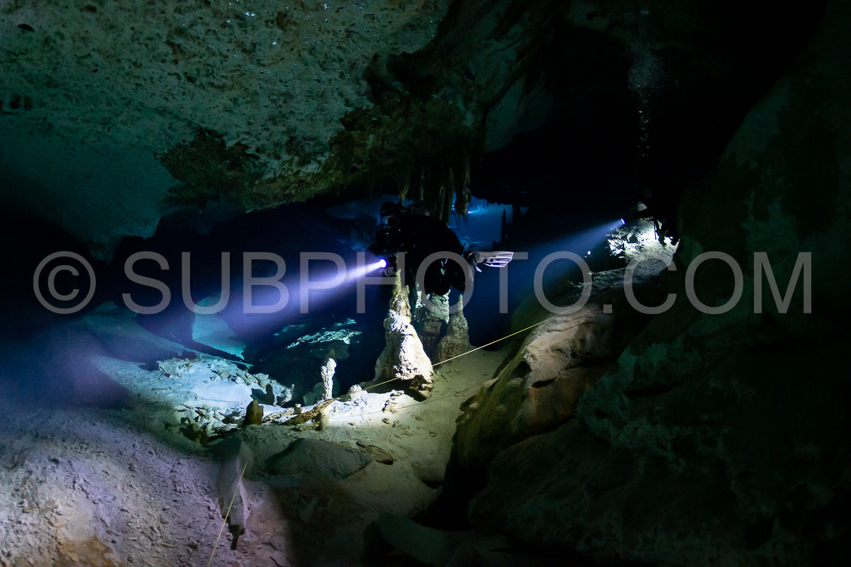 cave diver instructor leading a group of divers in a mexican cenote underwater