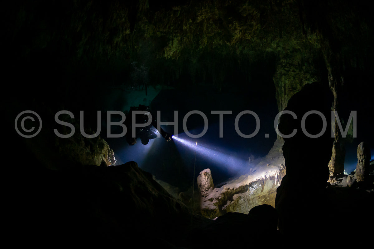 cave diver instructor leading a group of divers in a mexican cenote underwater