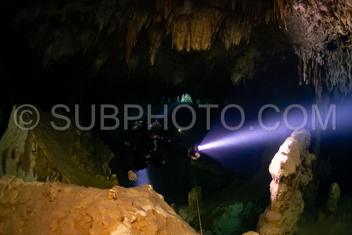 cave diver instructor leading a group of divers in a mexican cenote underwater