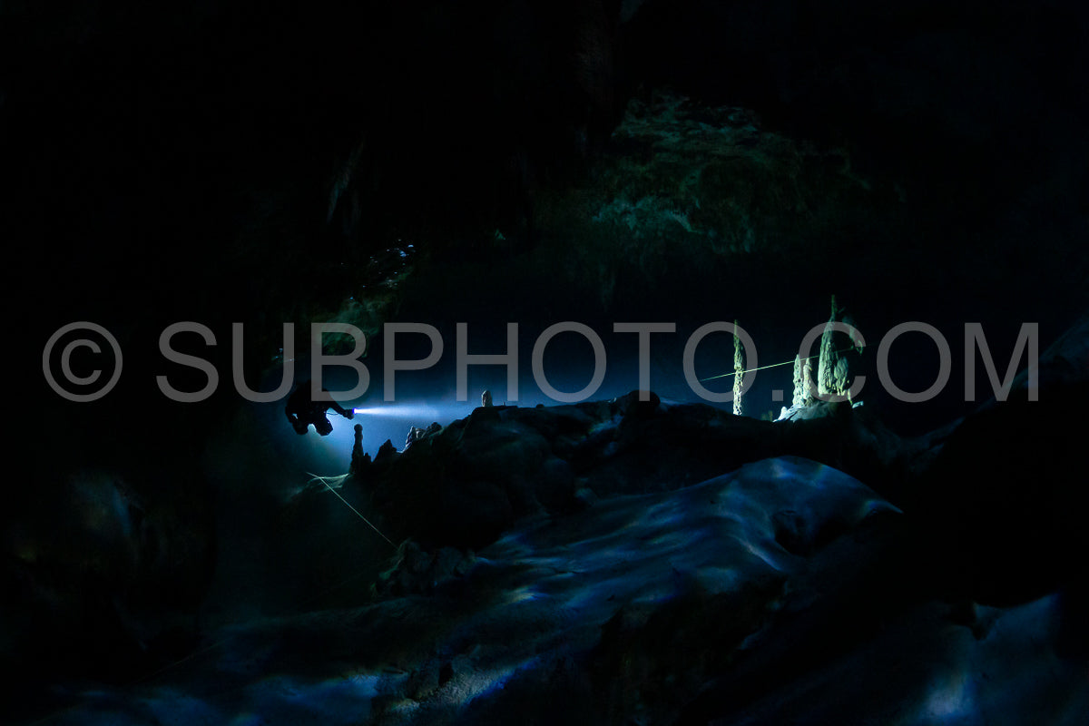 Photo de instructeur de plongée spéléo dirigeant un groupe de plongeurs dans un cenote mexicain sous l'eau