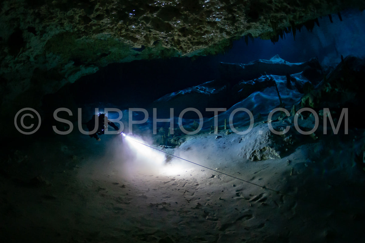 cave diver instructor leading a group of divers in a mexican cenote underwater