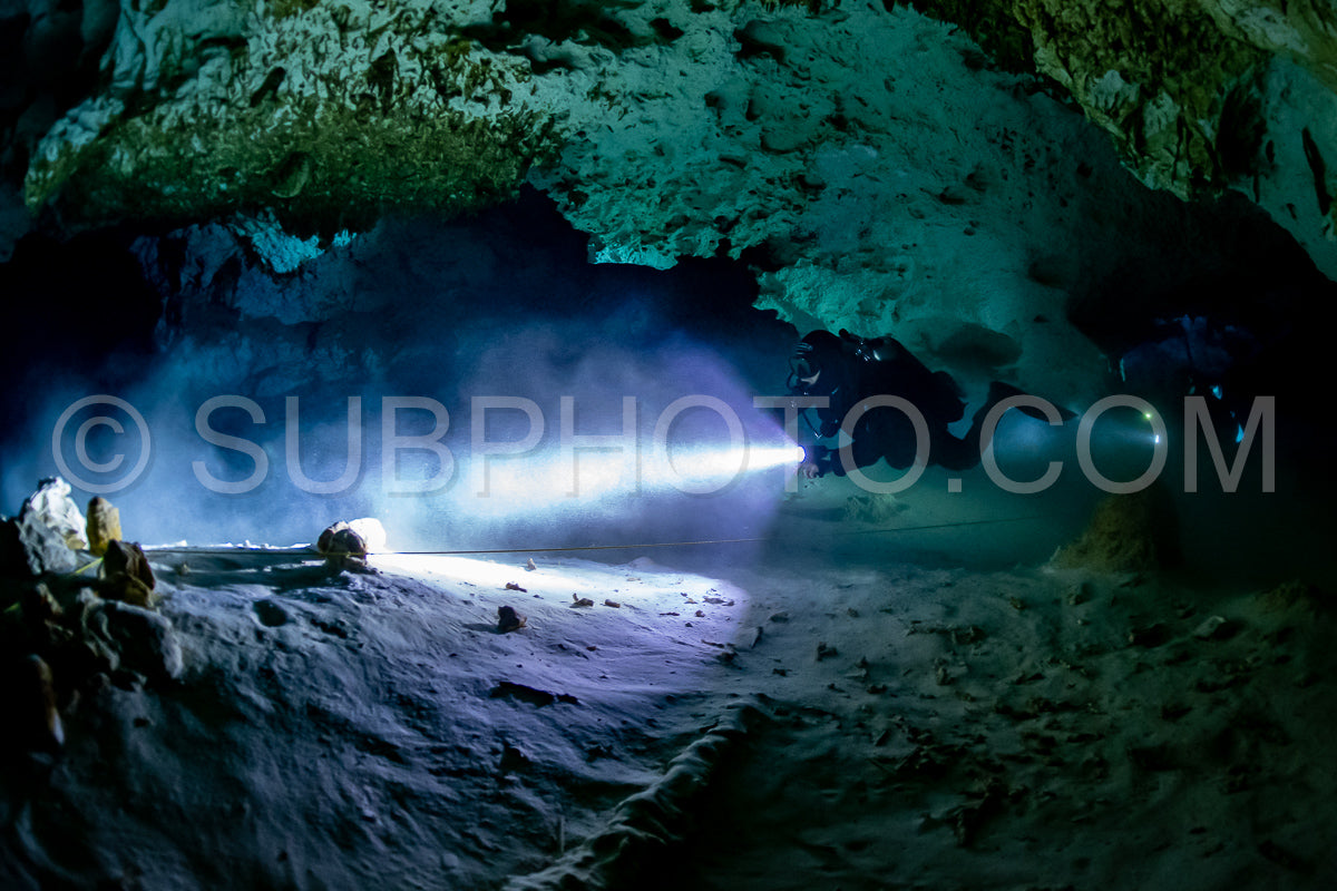 cave diver instructor leading a group of divers in a mexican cenote underwater