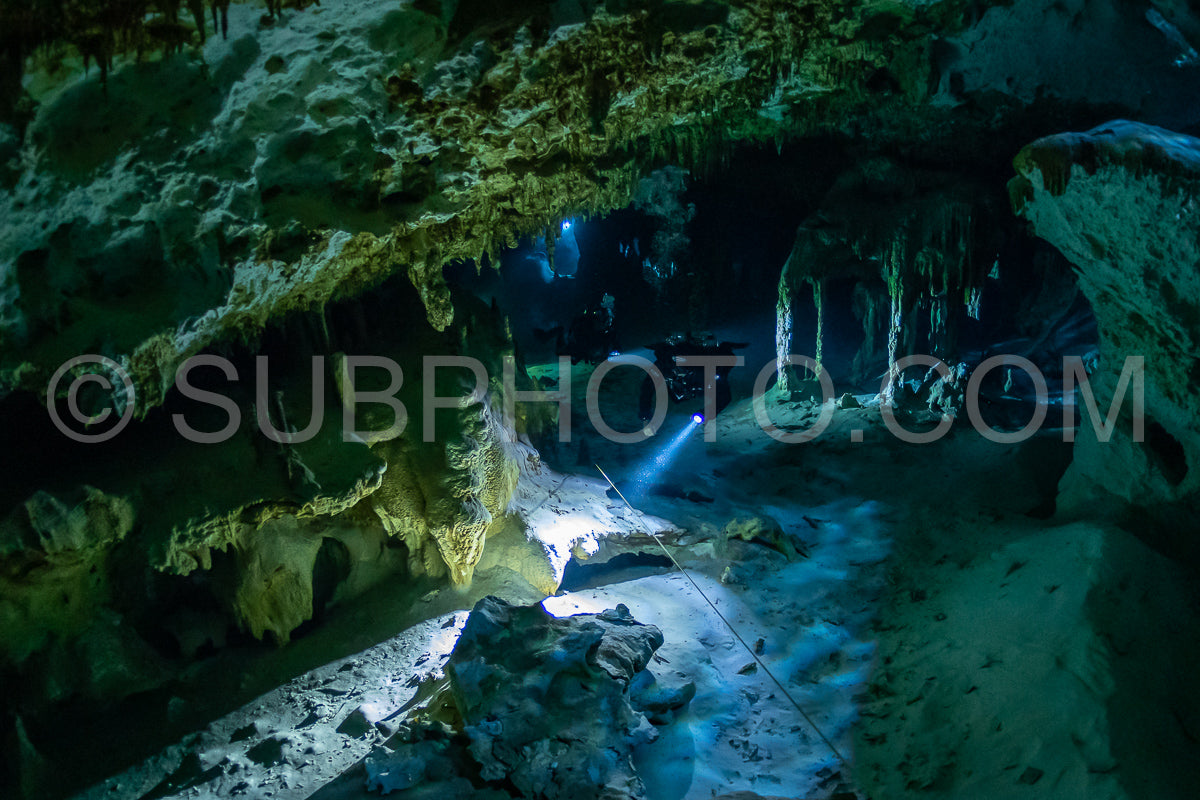 cave diver instructor leading a group of divers in a mexican cenote underwater