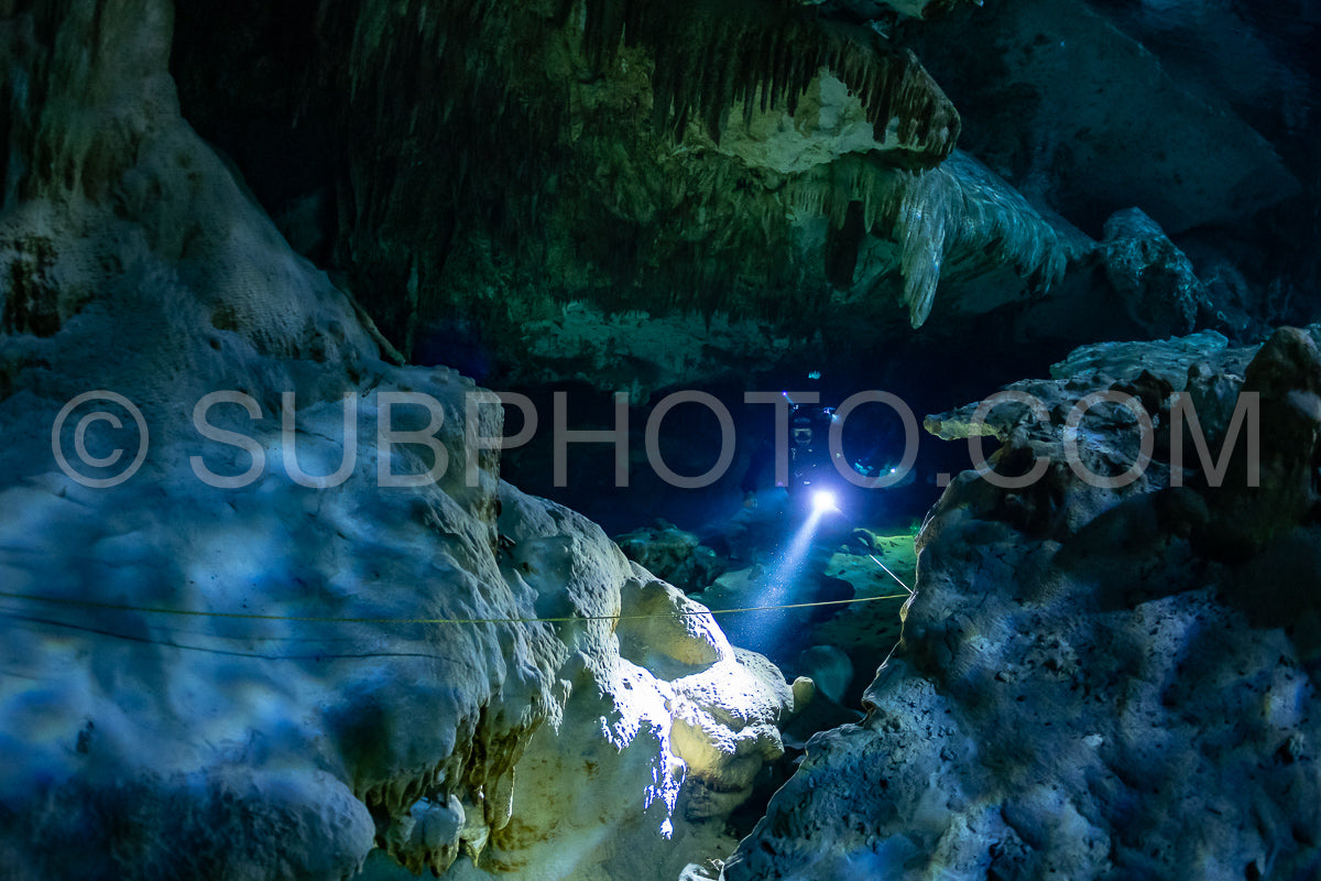 cave diver instructor leading a group of divers in a mexican cenote underwater