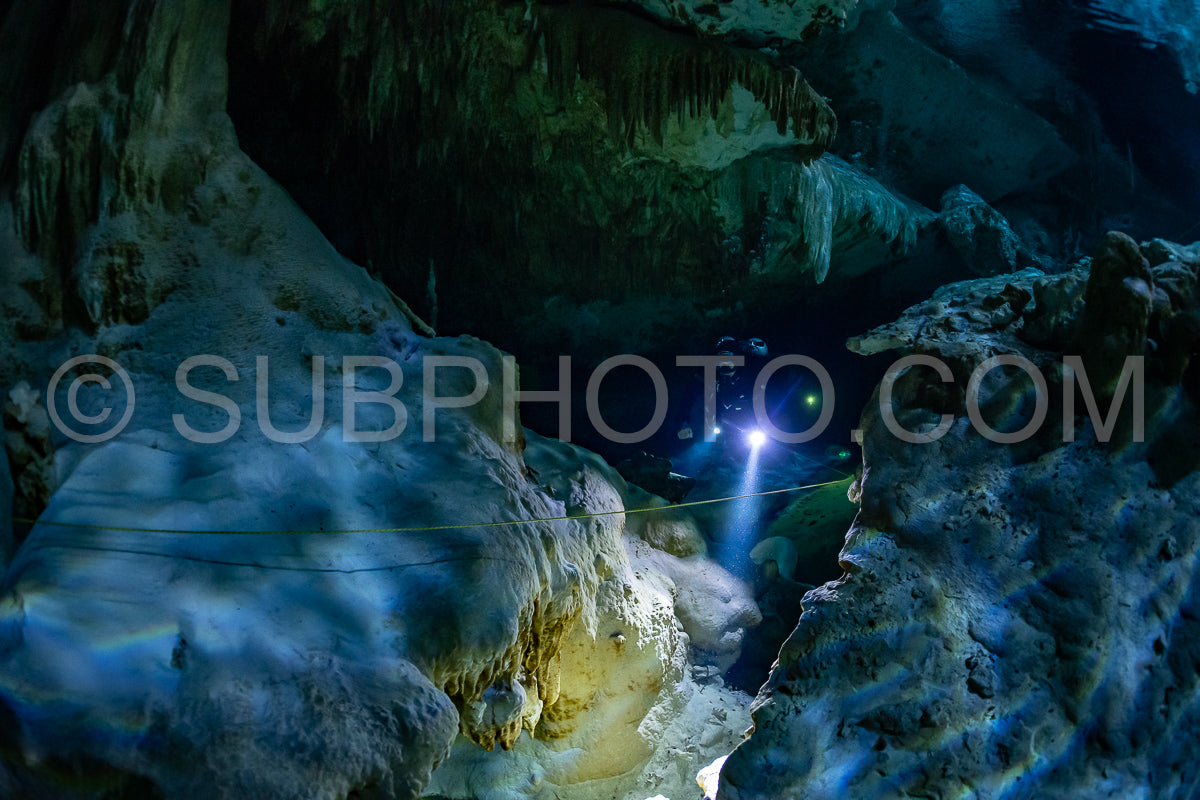 cave diver instructor leading a group of divers in a mexican cenote underwater