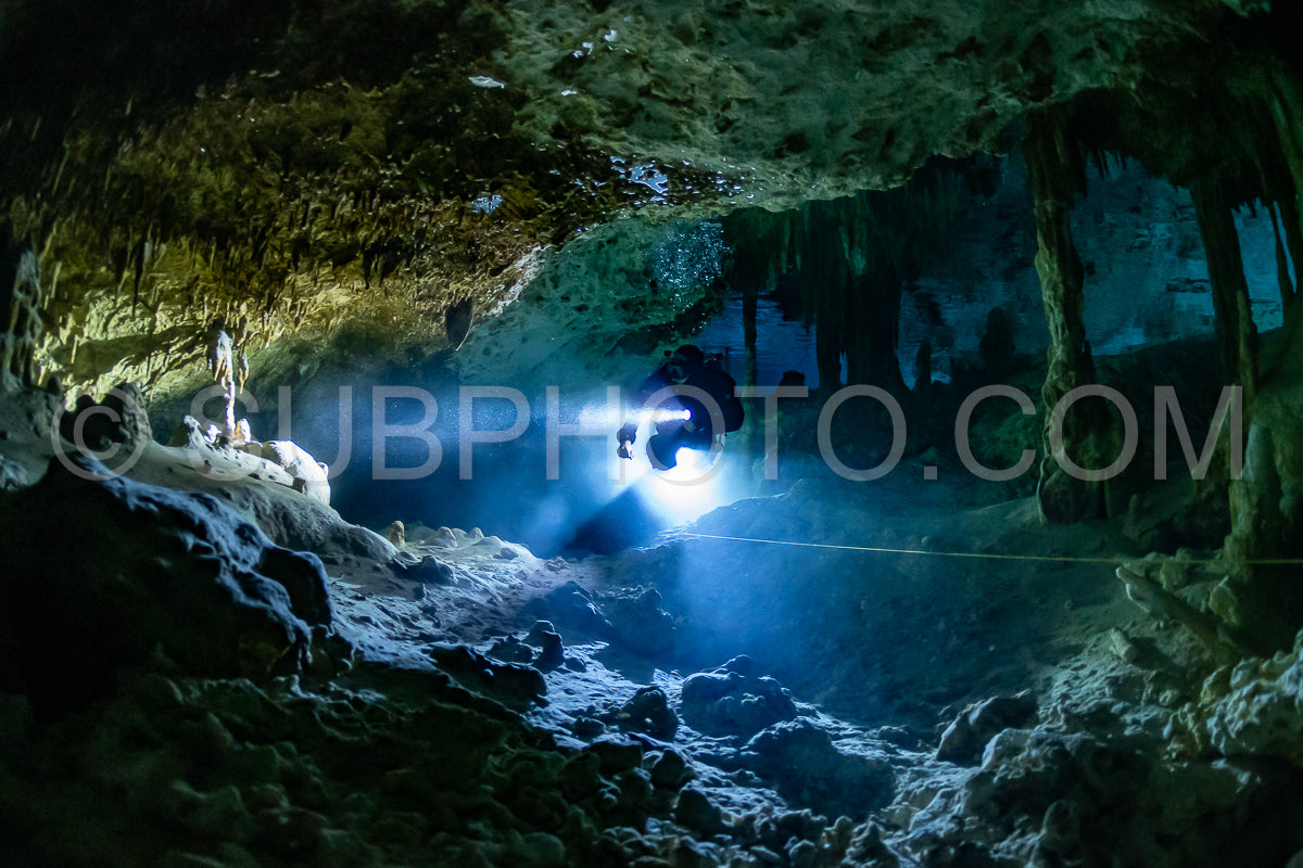 cave diver instructor leading a group of divers in a mexican cenote underwater