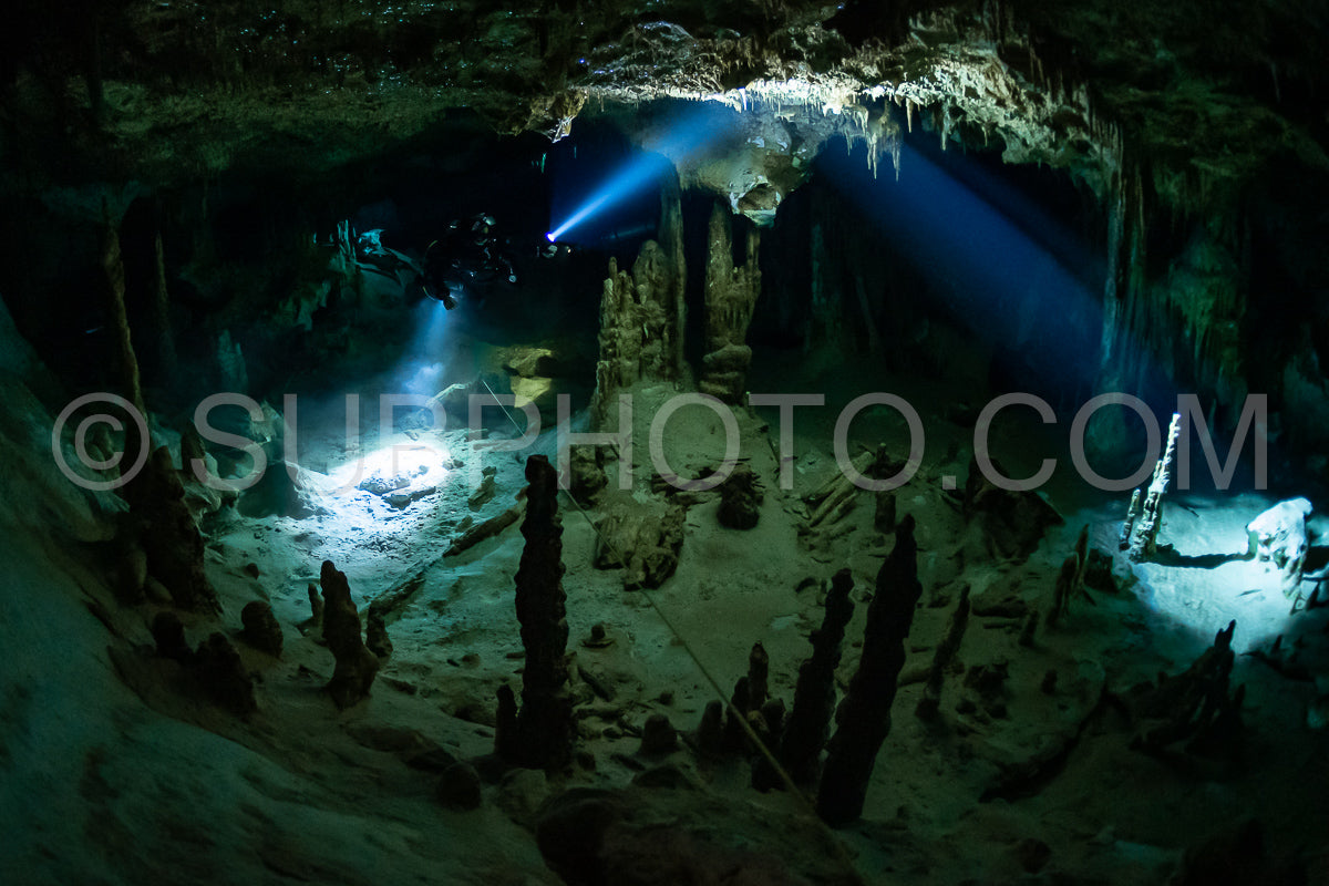cave diver instructor leading a group of divers in a mexican cenote underwater