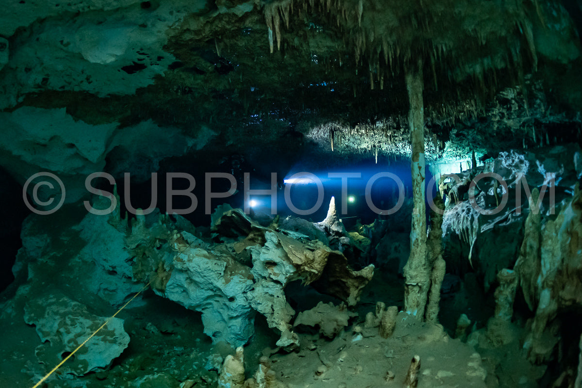 cave diver instructor leading a group of divers in a mexican cenote underwater