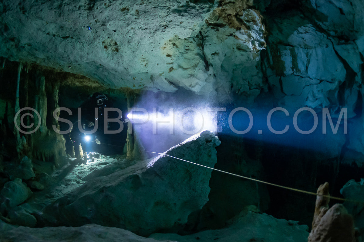 cave diver instructor leading a group of divers in a mexican cenote underwater