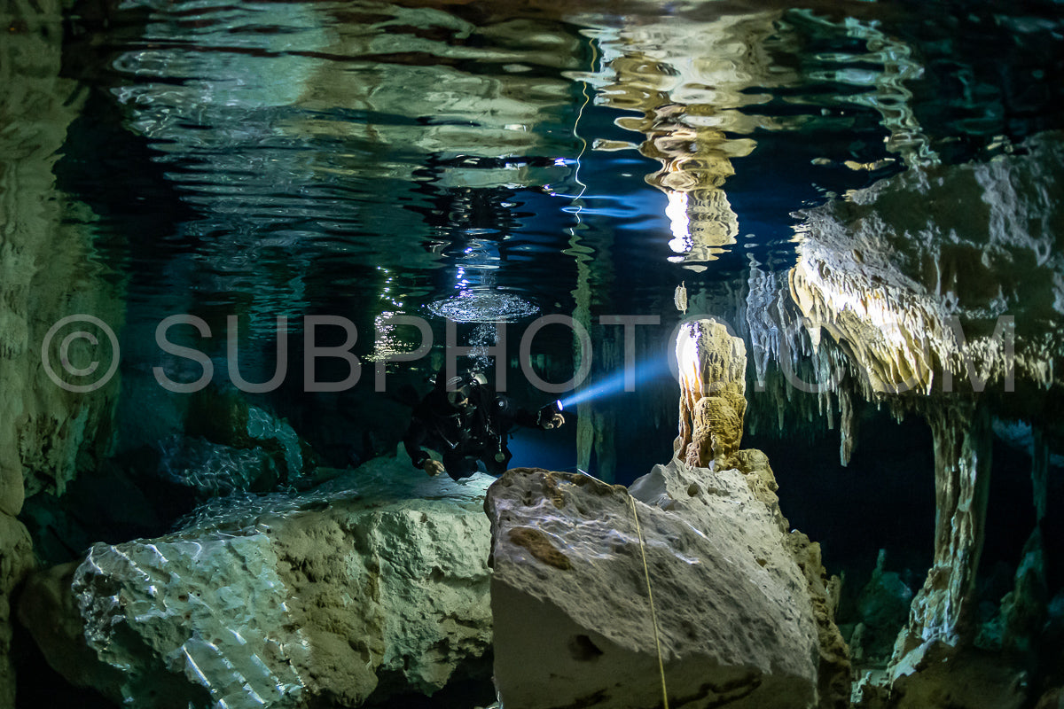 Photo de instructeur de plongée spéléo dirigeant un groupe de plongeurs dans un cenote mexicain sous l'eau