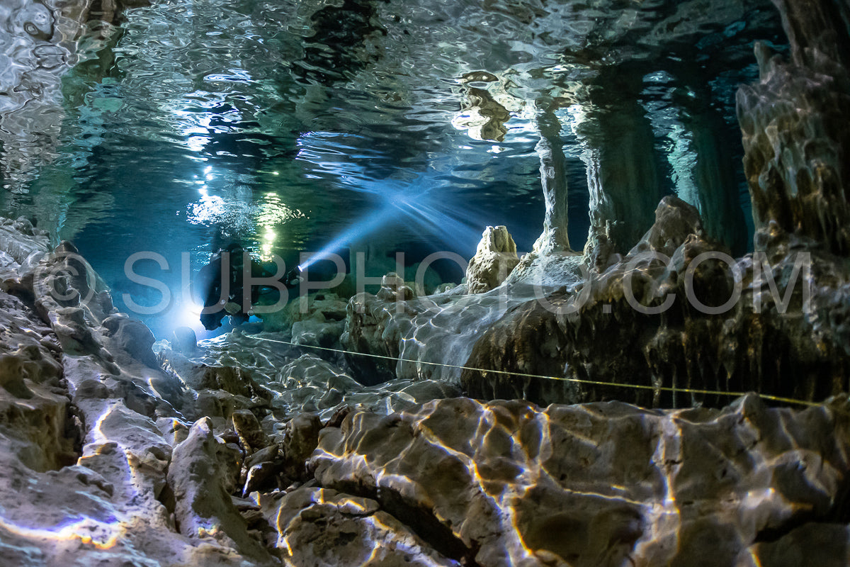 cave diver instructor leading a group of divers in a mexican cenote underwater