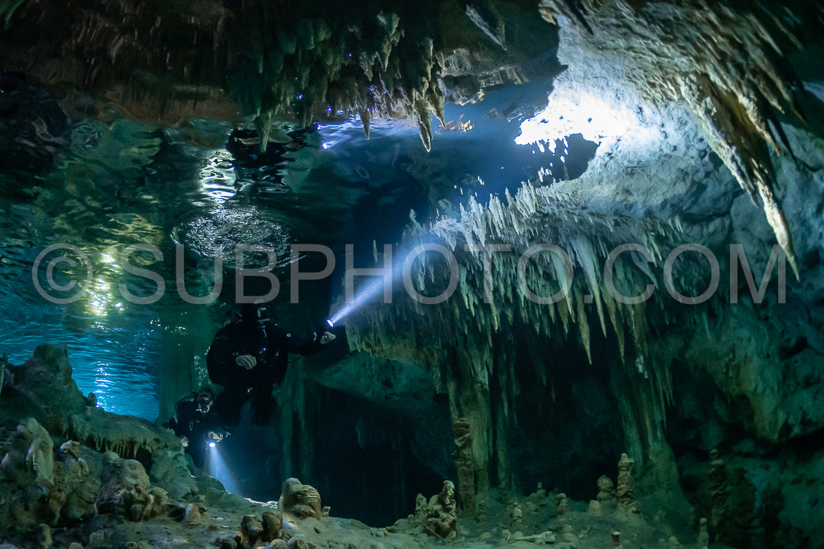 cave diver instructor leading a group of divers in a mexican cenote underwater