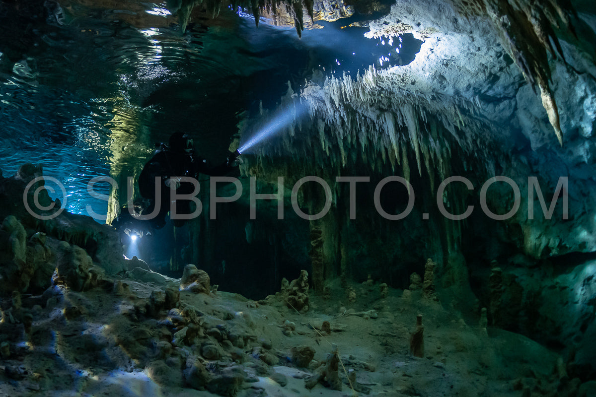cave diver instructor leading a group of divers in a mexican cenote underwater