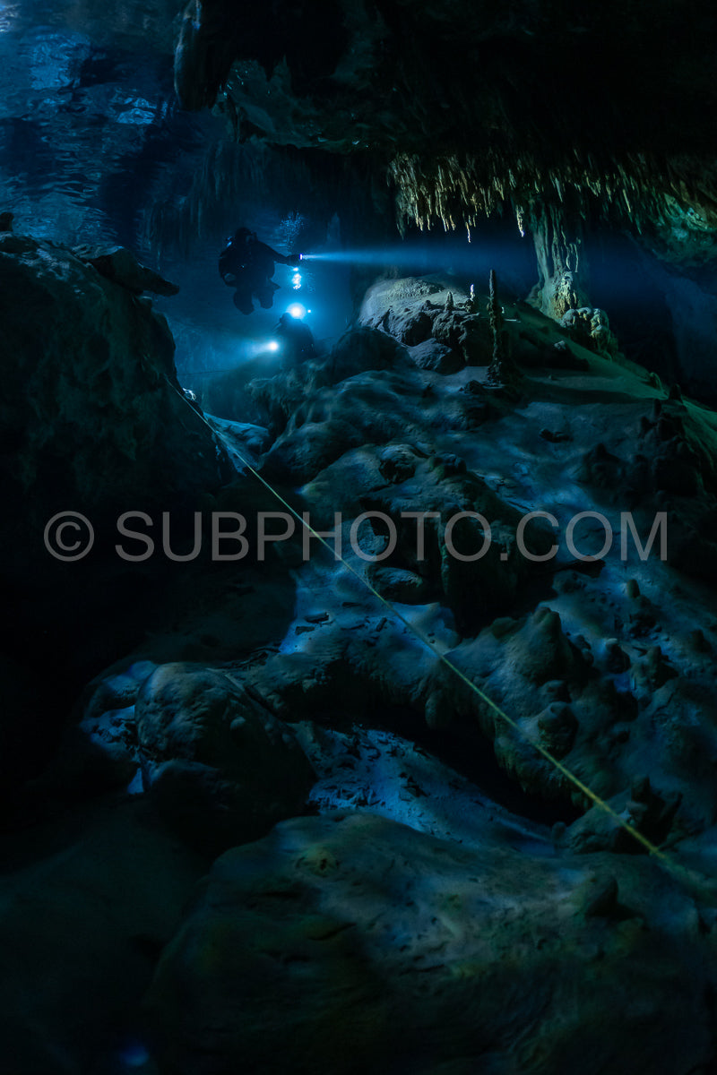 Photo de instructeur de plongée spéléo dirigeant un groupe de plongeurs dans un cenote mexicain sous l'eau