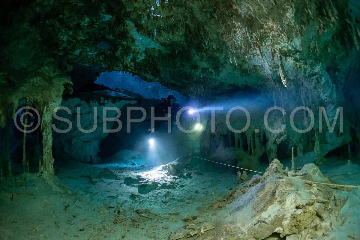 cave diver instructor leading a group of divers in a mexican cenote underwater