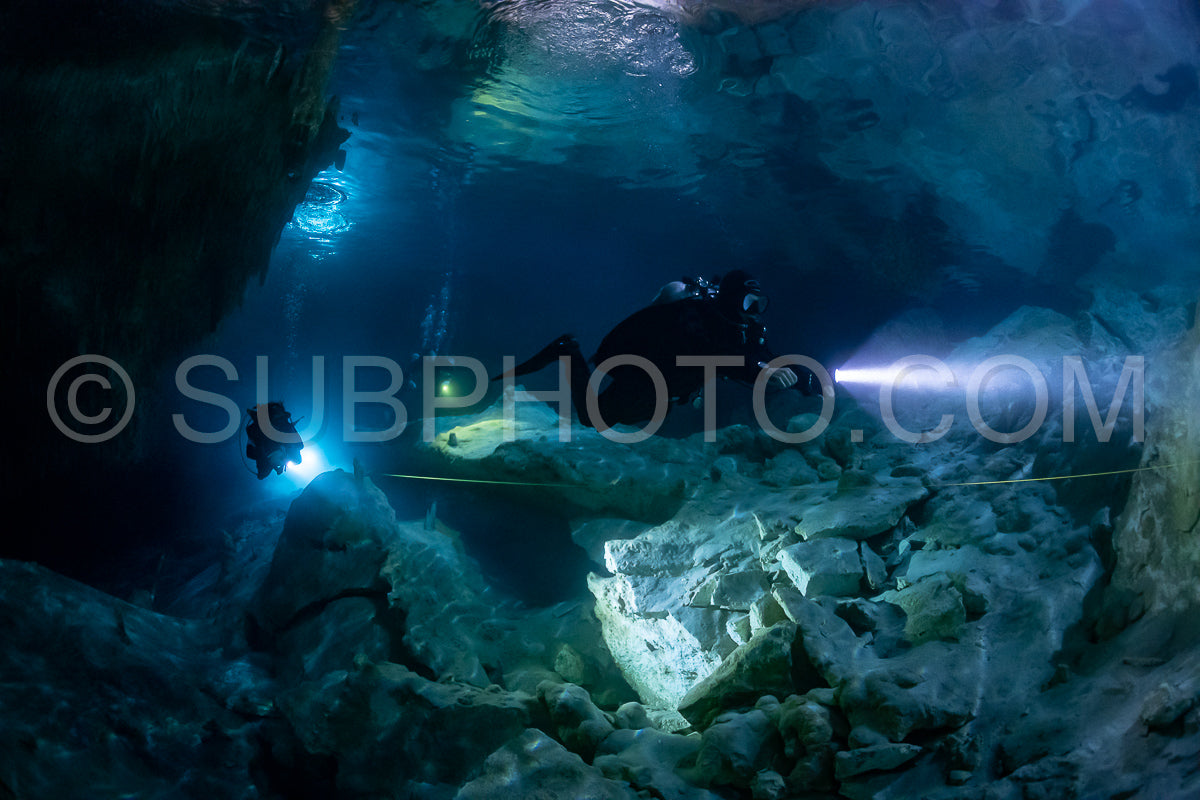cave diver instructor leading a group of divers in a mexican cenote underwater