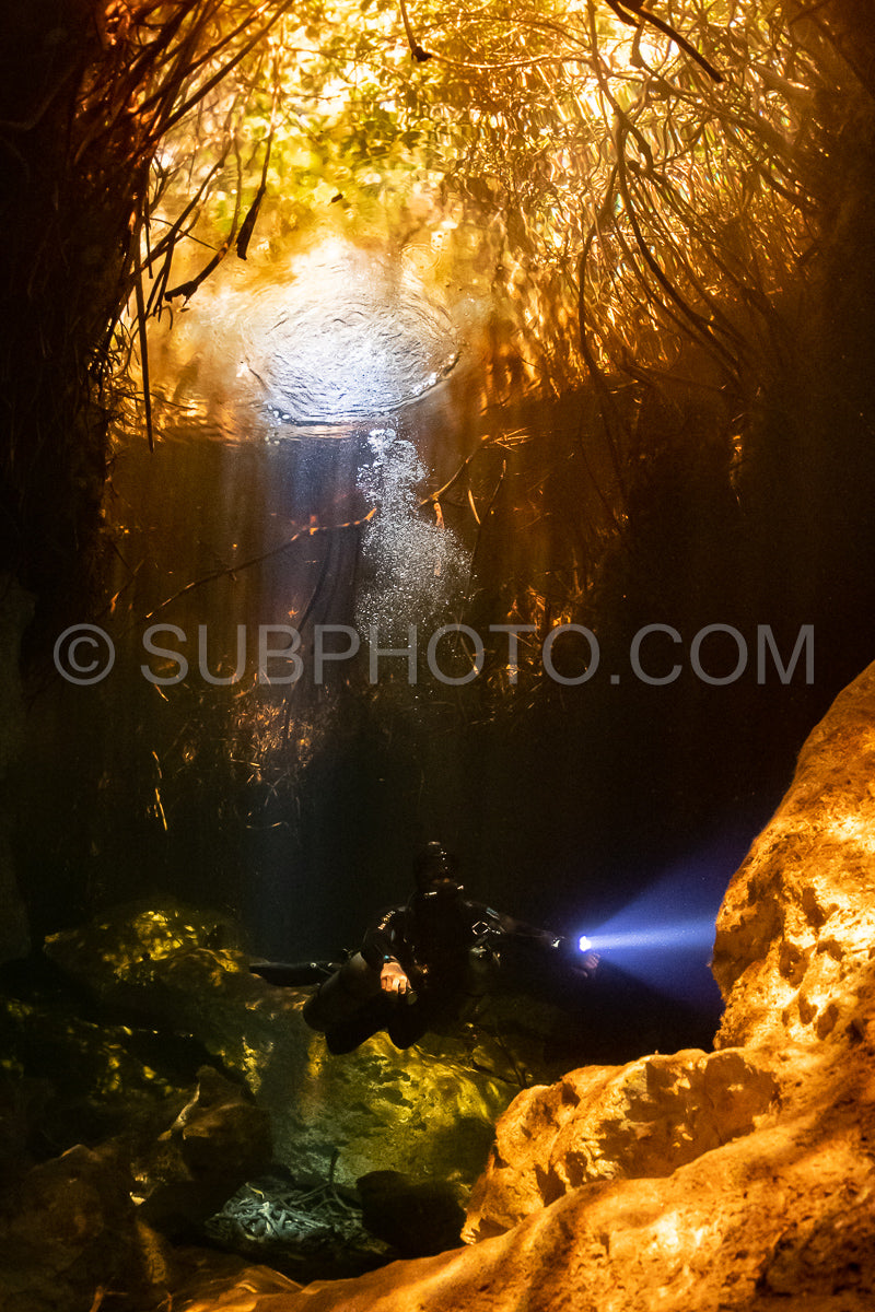 cave diver instructor leading a group of divers in a mexican cenote underwater