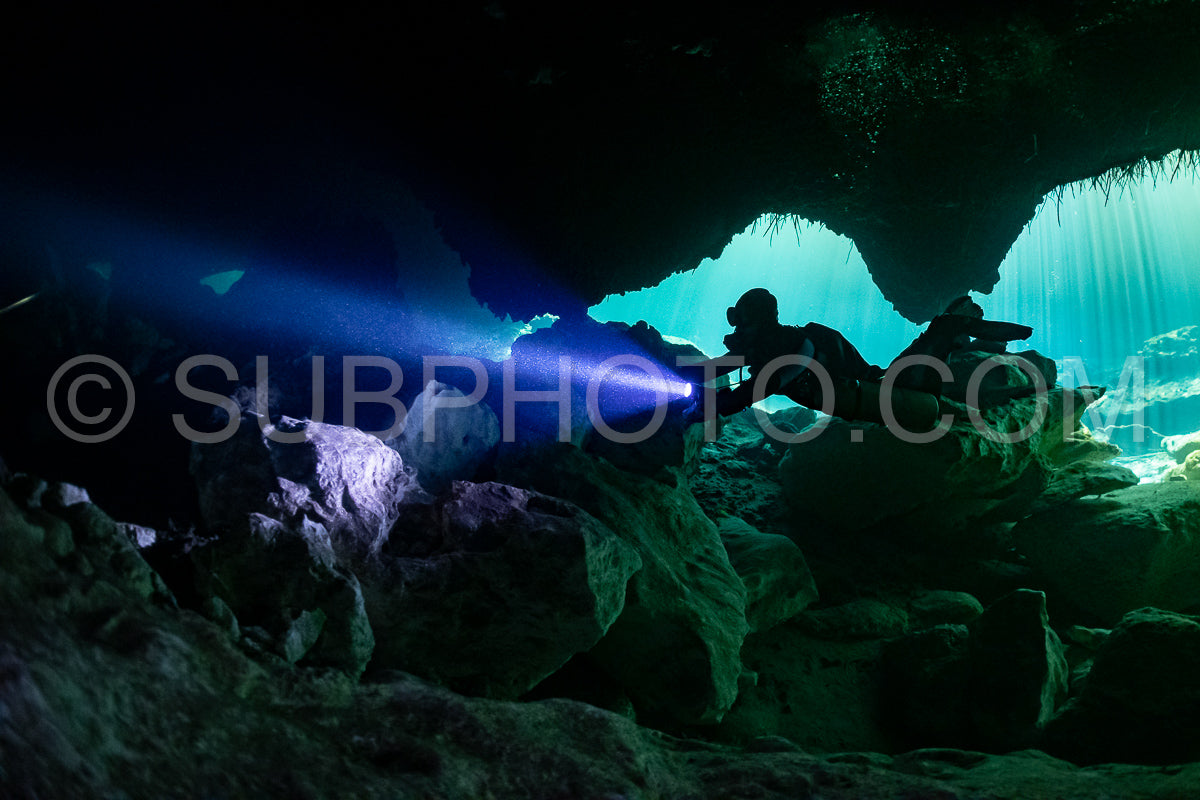 Photo de instructeur de plongée spéléo dirigeant un groupe de plongeurs dans un cenote mexicain sous l'eau