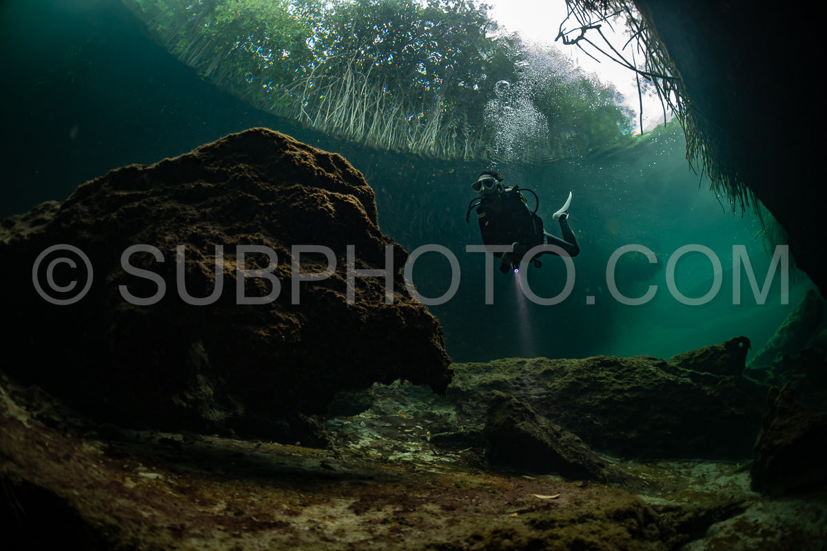 cave diver instructor leading a group of divers in a mexican cenote underwater