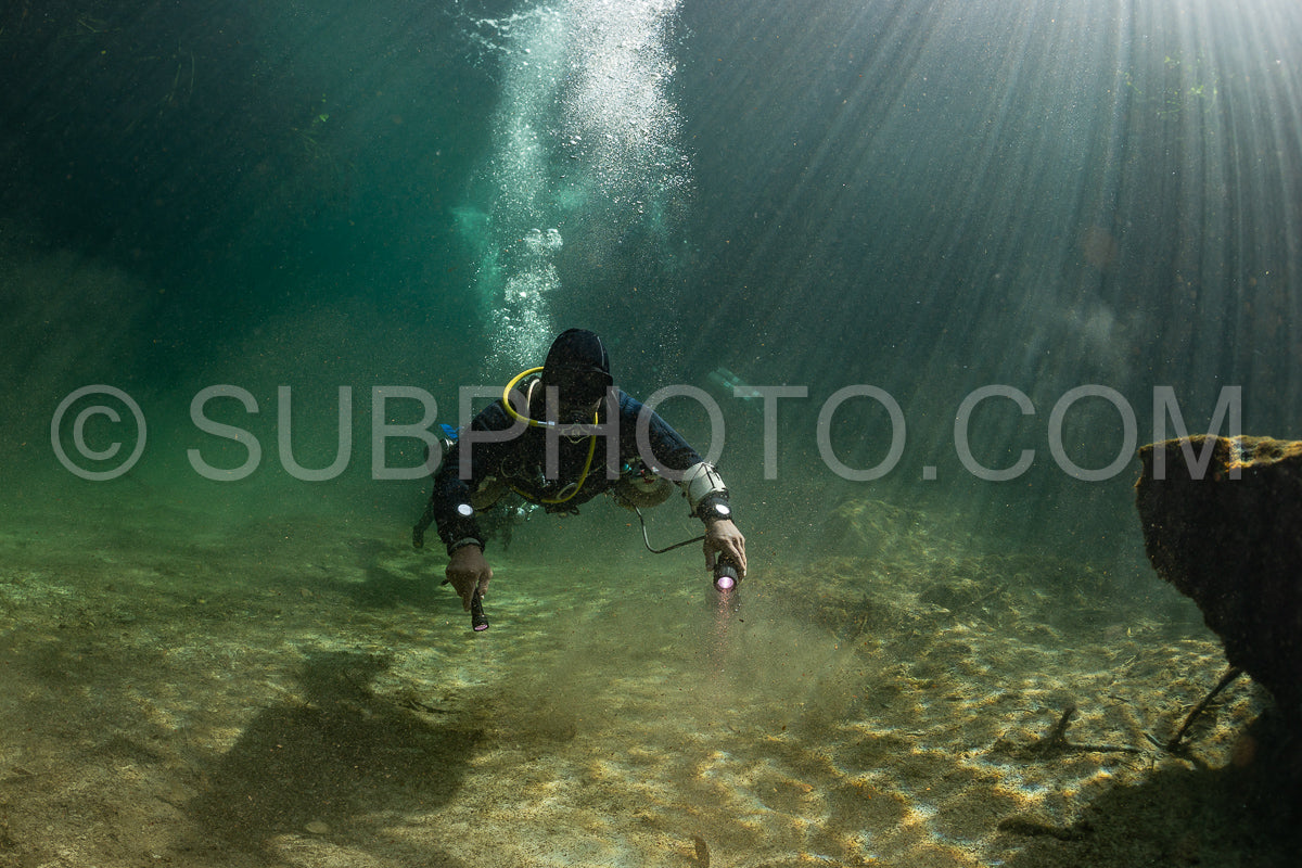 cave diver instructor leading a group of divers in a mexican cenote underwater