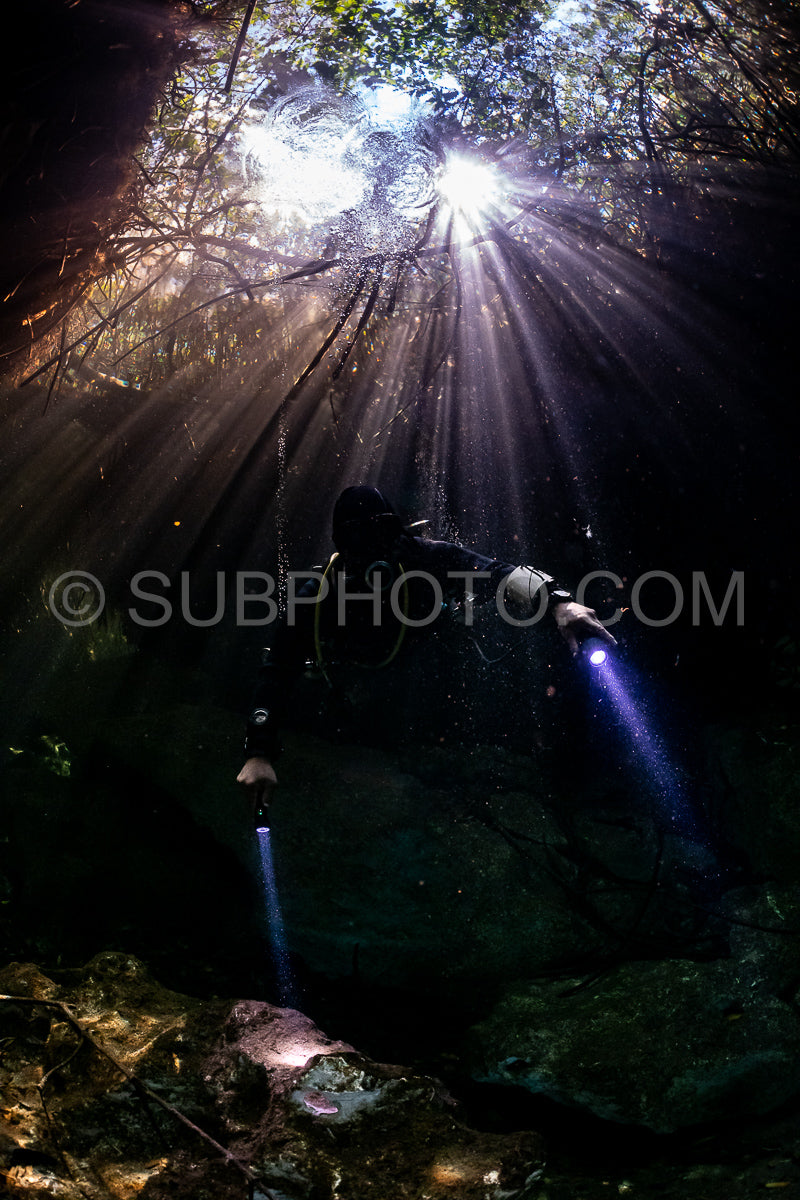 cave diver instructor leading a group of divers in a mexican cenote underwater