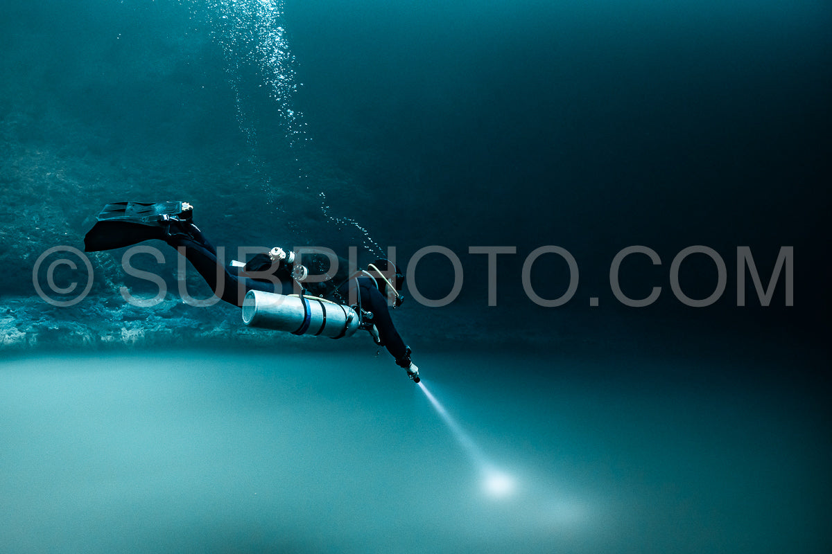 Photo de instructeur de plongée spéléo dirigeant un groupe de plongeurs dans un cenote mexicain sous l'eau