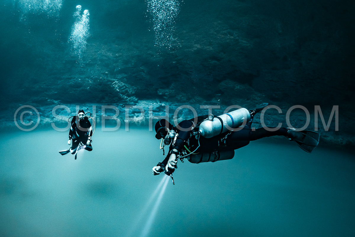 Photo de instructeur de plongée spéléo dirigeant un groupe de plongeurs dans un cenote mexicain sous l'eau