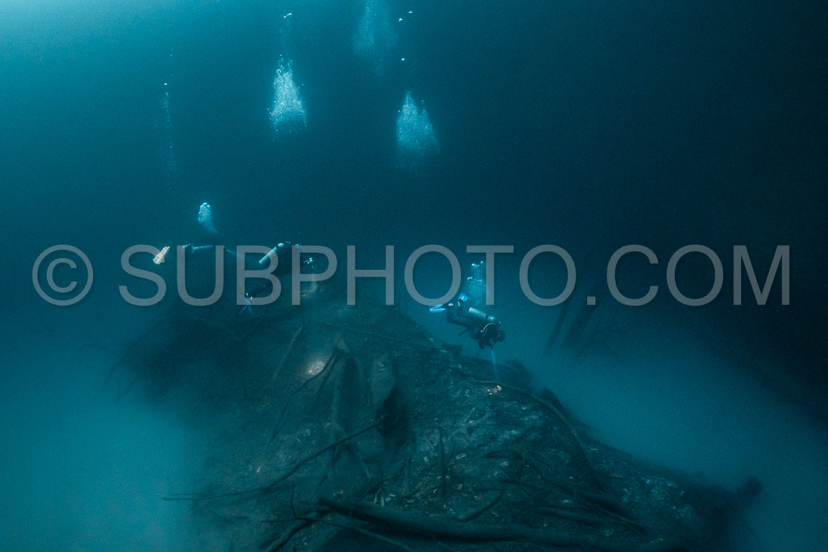 Photo de instructeur de plongée spéléo dirigeant un groupe de plongeurs dans un cenote mexicain sous l'eau