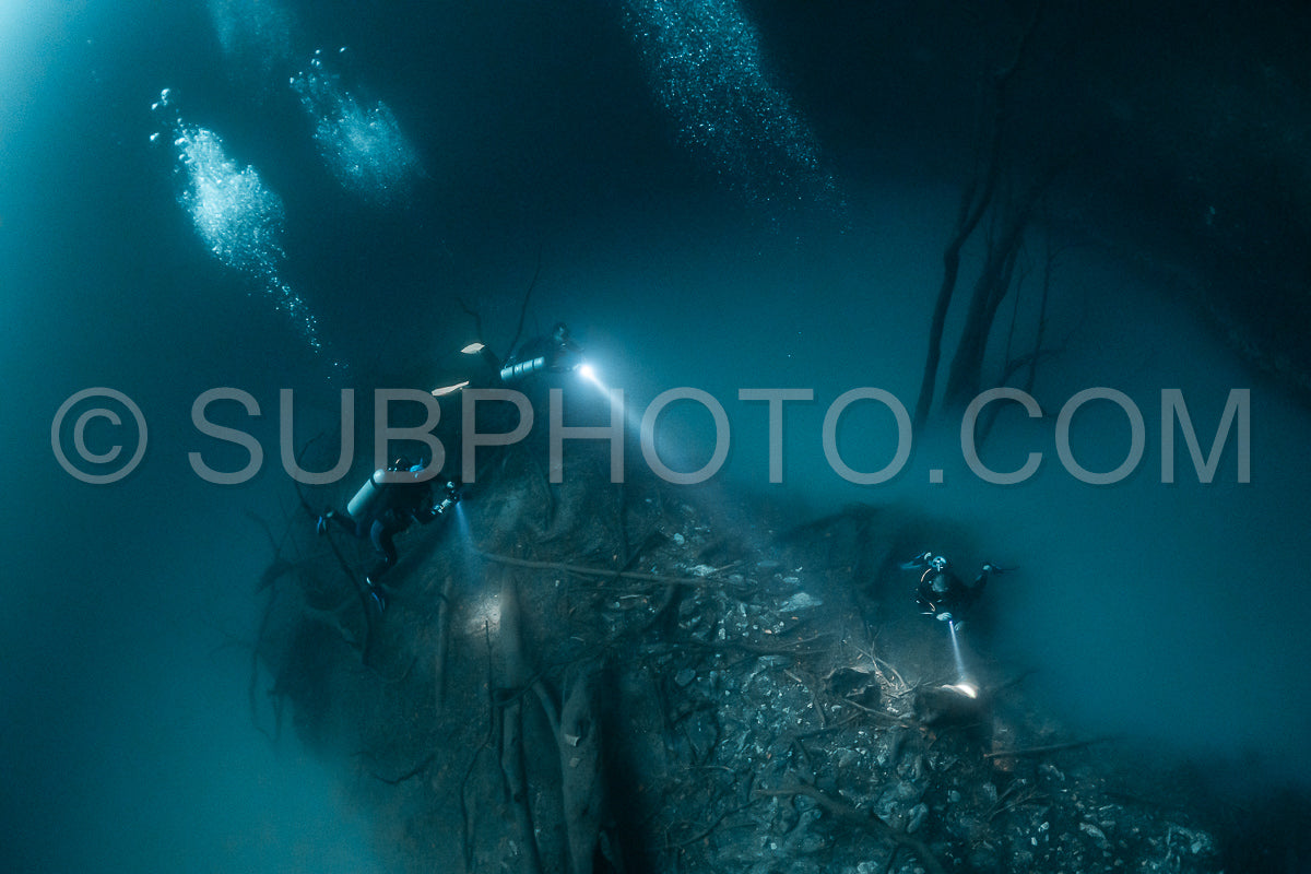 cave diver instructor leading a group of divers in a mexican cenote underwater