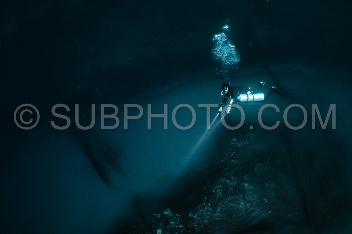 Photo de instructeur de plongée spéléo dirigeant un groupe de plongeurs dans un cenote mexicain sous l'eau