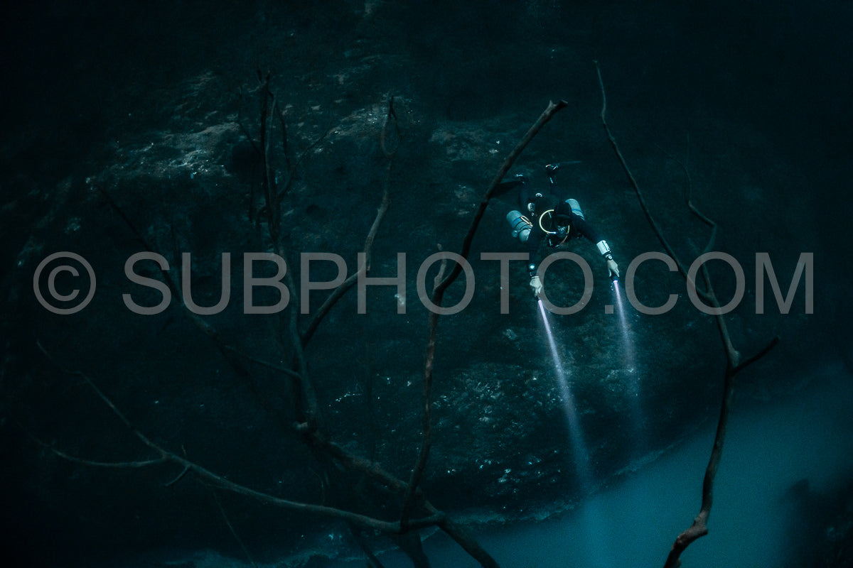 cave diver instructor leading a group of divers in a mexican cenote underwater