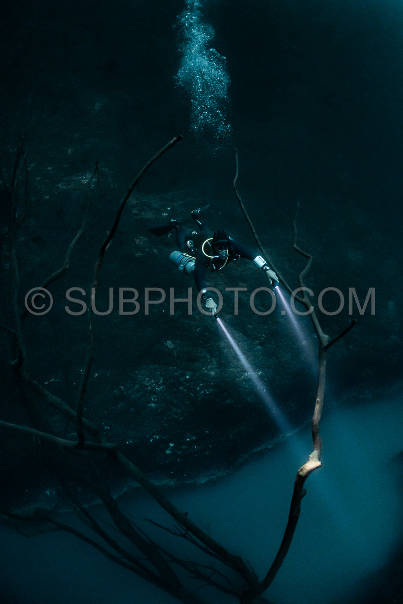 cave diver instructor leading a group of divers in a mexican cenote underwater