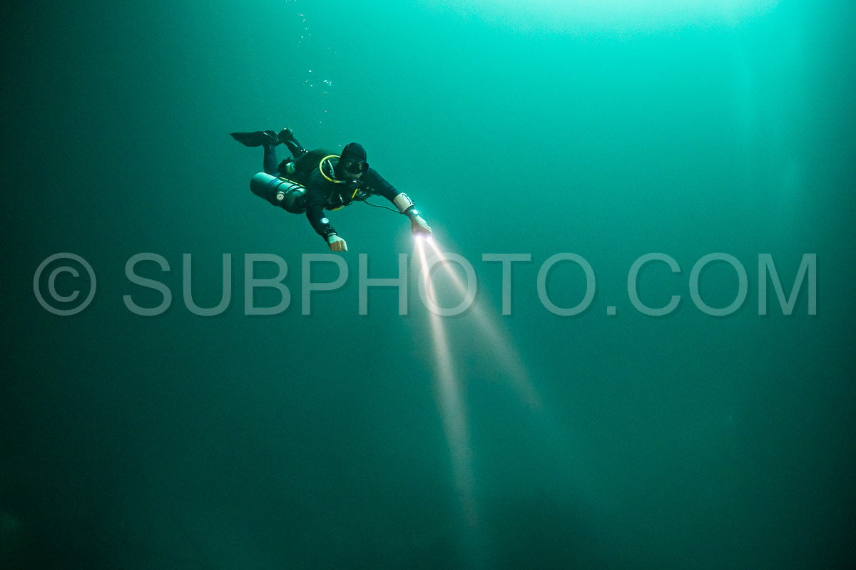 Photo de instructeur de plongée spéléo dirigeant un groupe de plongeurs dans un cenote mexicain sous l'eau