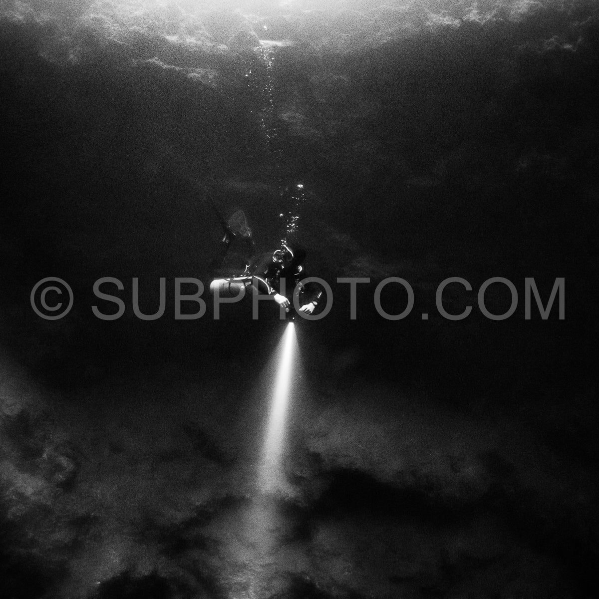 cave diver instructor leading a group of divers in a mexican cenote underwater