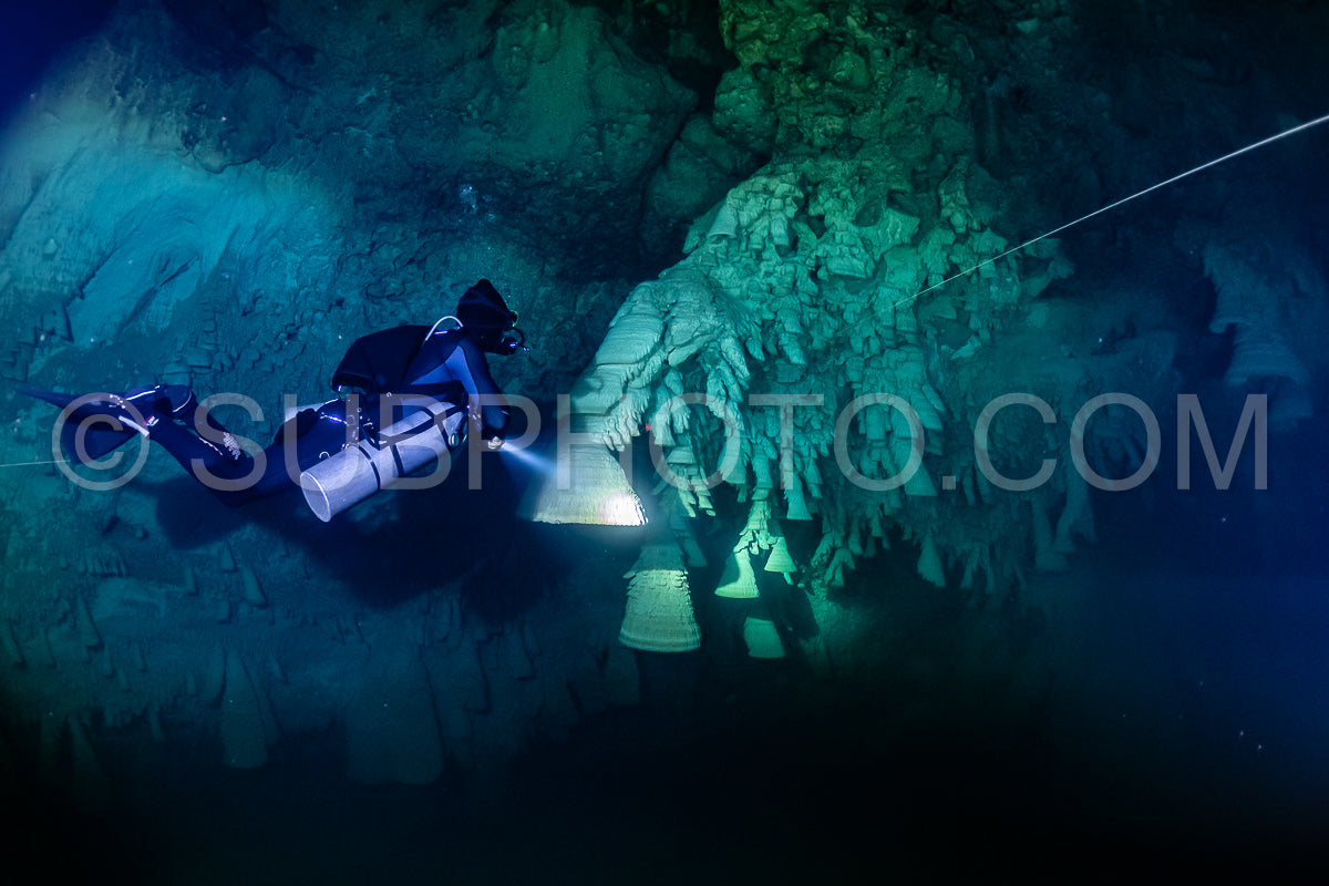 Photo de instructeur de plongée spéléo dirigeant un groupe de plongeurs dans un cenote mexicain sous l'eau
