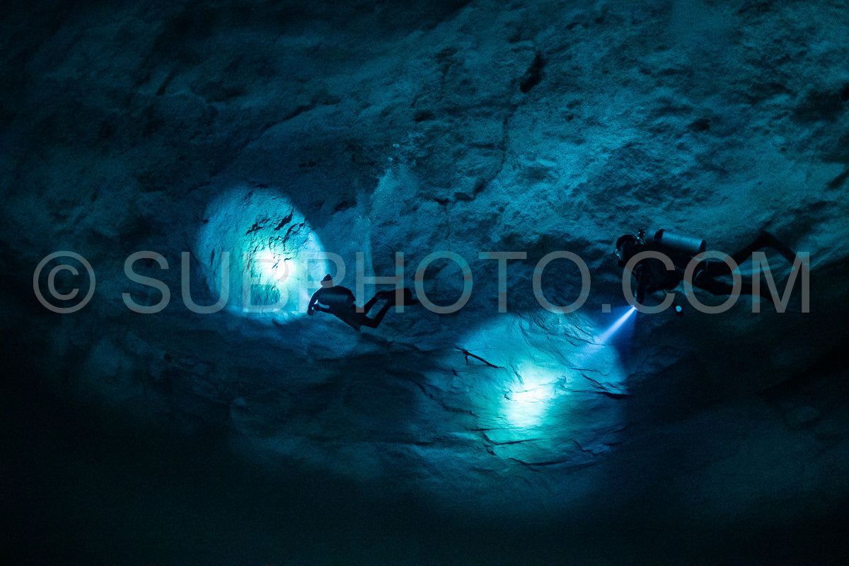 cave diver instructor leading a group of divers in a mexican cenote underwater